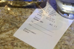 A receipt on a restaruant table. 