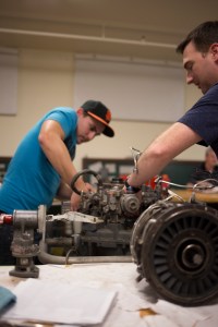 Ben Bolin and John Stagg work on a turbine engine. Photo by Evan E. Duran.